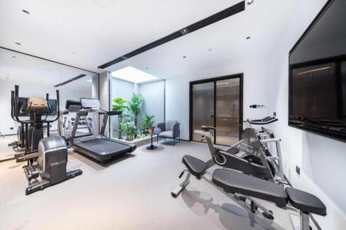 a gym with cardio machines and a flat screen tv at Atour Hotel Jinan Tangyan Century Avenue in Jinan