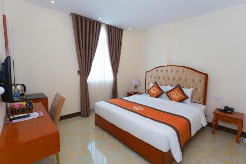 sypialnia z łóżkiem, biurkiem i telewizorem w obiekcie Ngọc Long Châu Hotel 