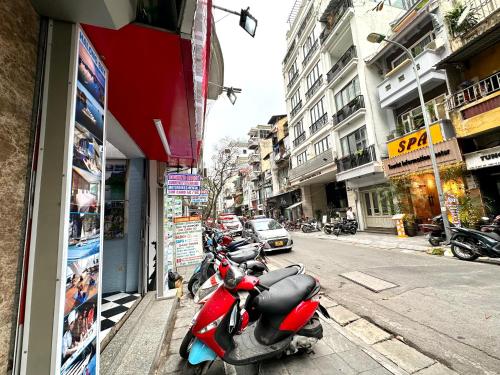 una fila de scooters estacionados al lado de una calle en Hanoi Old Quarter Homestay, en Hanói
