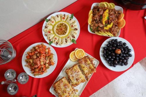 una tavola con piatti di cibo su un tavolo rosso di ALAZMI HOTEL a Al Khān