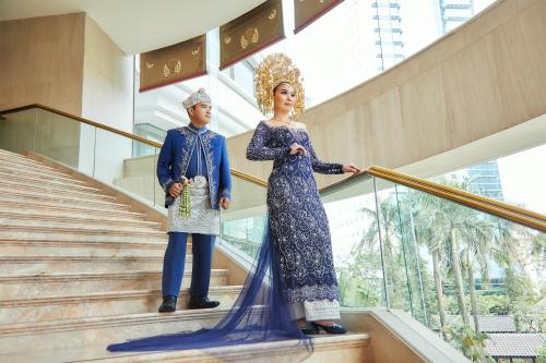 two man and woman standing on stairs in a building at Shangri-La Jakarta in Jakarta