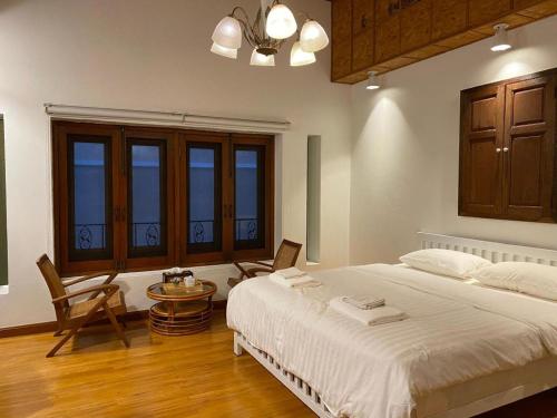 a bedroom with a large bed and a table and chairs at Me Design khao yai in Mu Si