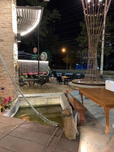 une terrasse avec un banc, une table et des tables dans l'établissement Me Design khao yai, à Ban Wa Kachieo