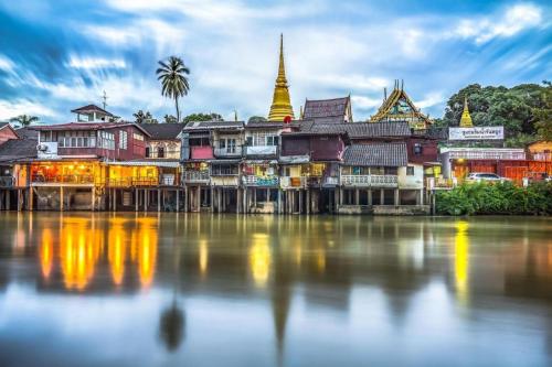 a group of buildings next to a body of water at เมล่อนลอยฟ้า in Ban Kaeo
