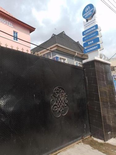 Una cerca negra con un montón de letreros de la calle. en Americana Hotel, en Oshodi