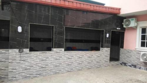 a black building with three windows and a speaker at Americana Hotel in Oshodi