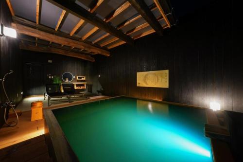uma piscina num quarto com uma mesa em MURE Beppu em Beppu