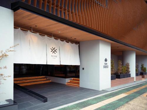 un bâtiment avec un groupe de bancs devant lui dans l'établissement MURE Beppu, à Beppu