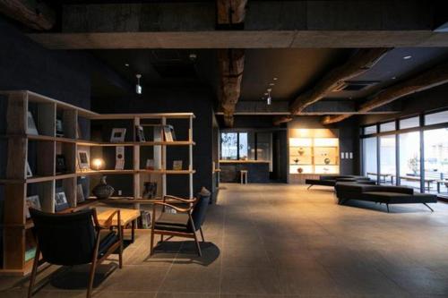 別府市にあるMURE Beppuの椅子、テーブル、窓が備わる広い客室です。