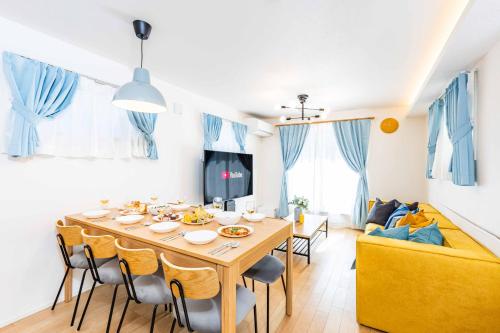a dining room with a table and chairs and a couch at Modern House Tokyo east in Tokyo