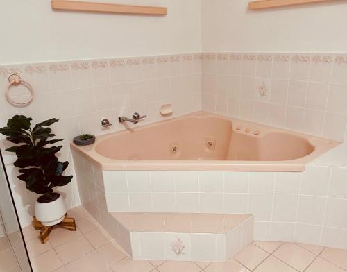 een bad in een badkamer met een potplant bij 5 Well St in Forster