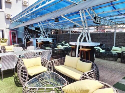 an outdoor patio with wicker chairs and tables at Easton Hill Continental Hotel in Enugu