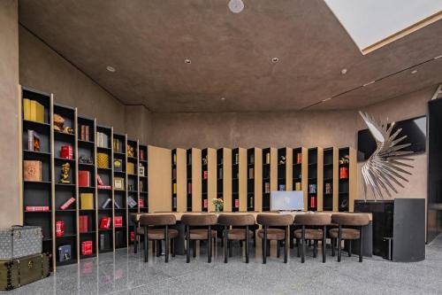 a room with a table and some chairs and shelves at Airfeel Hotel in Ziyang