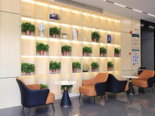 hol z krzesłami, stołami i roślinami na ścianie w obiekcie GreenTree Inn Express Fuyang University Town West High-Speed Railway Station w Fuyang