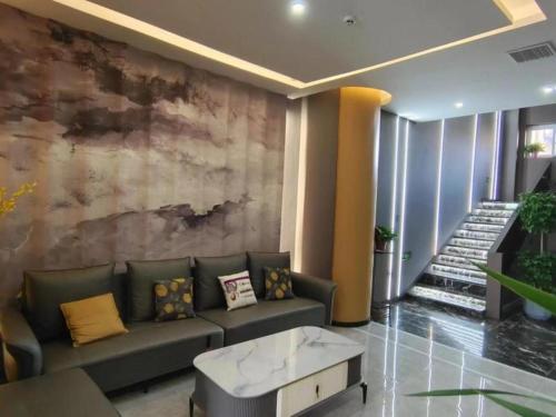 にあるShell Hotel Xuzhou Guanyin Airportのソファ付きのリビングルーム、壁