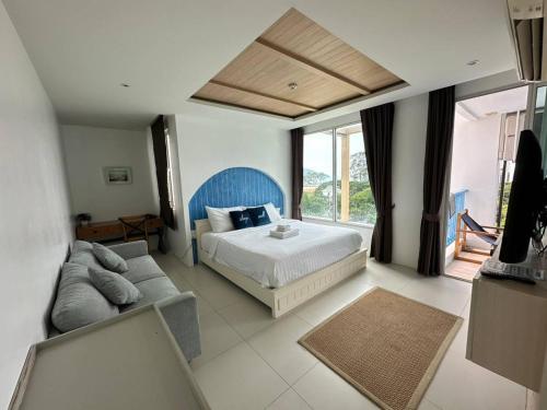 een slaapkamer met een bed en een bank bij Costa Beach Residence & Jacuzzi in Sattahip