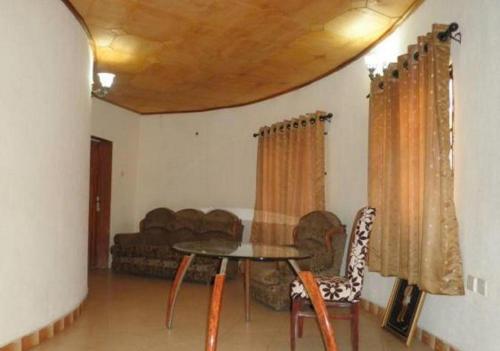 a living room with a table and a couch at Adap Hotel in Agbabiaka