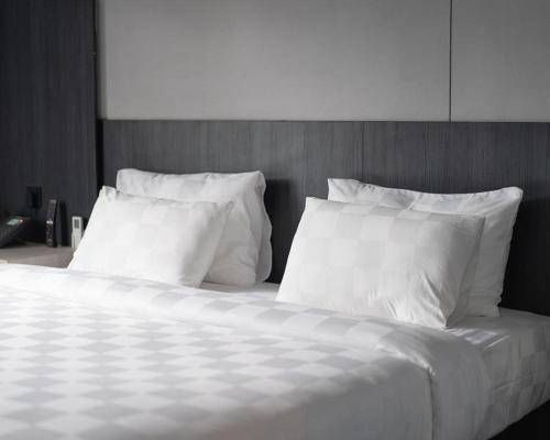 En eller flere senge i et værelse på Kyriad Hotel M2 Lampung