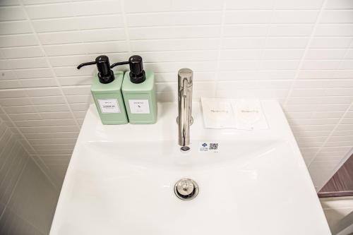 a white sink with a pair of glasses on it at น่าน ม่วนใจ Nan Muanjai Hotel in Pua