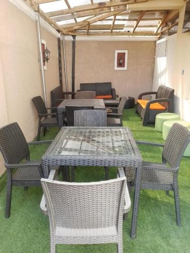 eine Terrasse mit Tischen, Stühlen und einem Sofa in der Unterkunft Juliet's Place Residence & Hotel in Eregun