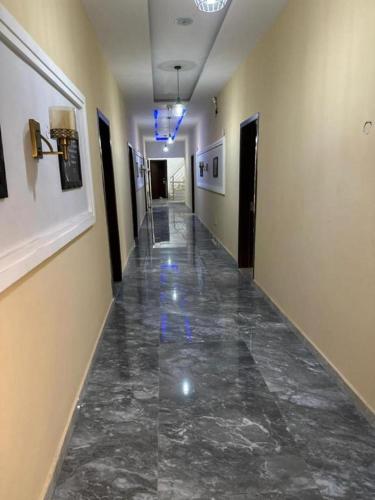 einen Flur mit Marmorboden in einem Gebäude in der Unterkunft Juliet's Place Residence & Hotel in Eregun