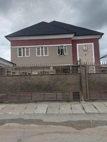 a house with a fence in front of it at Juliet's Place Residence & Hotel in Eregun