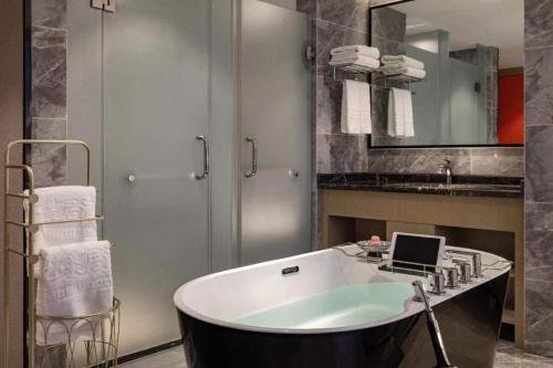 y baño con bañera y lavamanos. en Yiwu Bo Yi Mei Ju Hotel (International Trade Center), en Liucun
