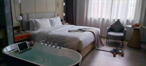um quarto de hotel com uma cama e uma banheira em Yiwu Bo Yi Mei Ju Hotel (International Trade Center) em Liucun