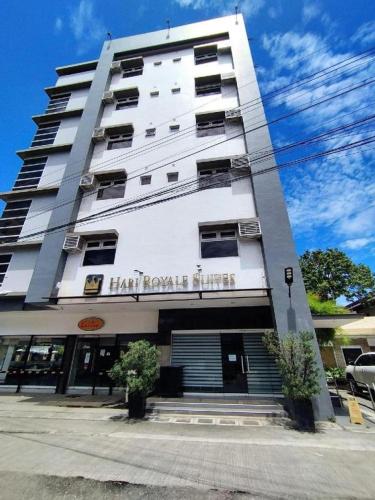 een hoog wit gebouw met een bord erop bij Hari Royale Suites in Davao City