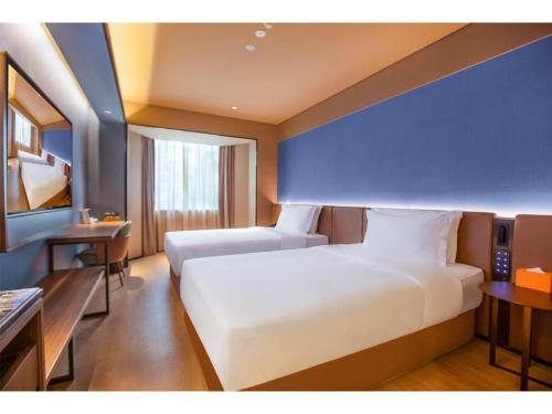En eller flere senge i et værelse på Orange Hotel Guangzhou Ouzhuang Metro Station