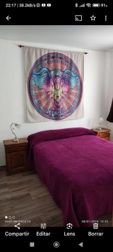 a bedroom with a purple bed with a painting on the wall at Alquimia Qi del Mar in Mar de Cobo