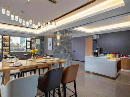 a kitchen and dining room with a table and chairs at Campanile Hotel Shenzhen Guanlan Goft in Tiantangwei