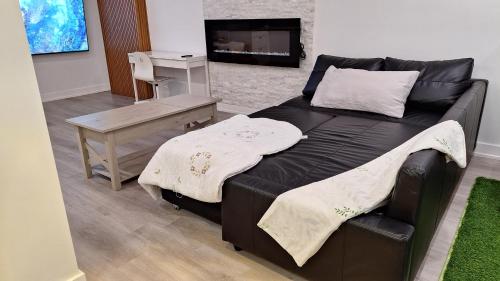 uma cama preta num quarto com uma mesa em Independent Studio Suite em Ottawa