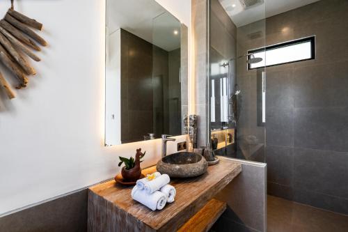 een badkamer met een wastafel en een spiegel bij Villa Leeloo by BaliSuperHost in Canggu