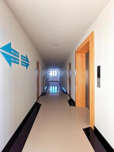 un couloir dans un bâtiment avec deux flèches sur le mur dans l'établissement Mali House Sakon Nakhon, à Sakon Nakhon