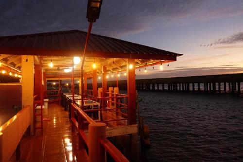 a dock with a building with lights on the water at Sunset Curly Bay Hotel & Resort in Tanjung Pinang 