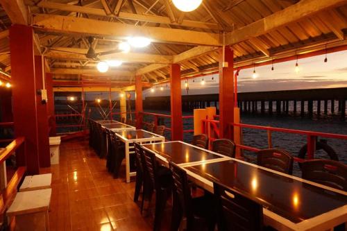 丹戎檳榔的住宿－Sunset Curly Bay Hotel & Resort，船上的酒吧,配有桌椅