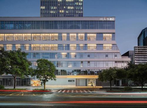 a large office building with a street in front of it at eLong Hotel (HUA Shenzhen Bay Branch) in Shenzhen