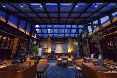 a restaurant with tables and chairs and a large ceiling at Blossom House Xuzhou Huilongwo Banyunting in Xuzhou