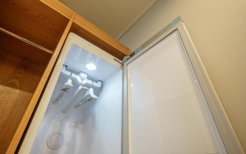 um chuveiro com uma porta de vidro na casa de banho em H Avenue Gyeongju em Gyeongju