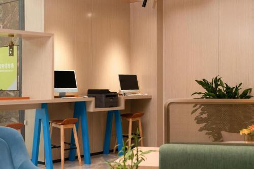 un bureau avec deux bureaux équipés de deux ordinateurs dans l'établissement Home2 Suites by Hilton Xishuangbanna, à Jinghong