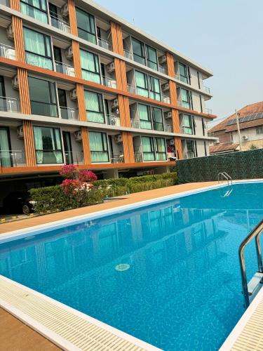 a swimming pool in front of a building at MAHIDOL CONDO มหิดลคอนโด in Chiang Mai