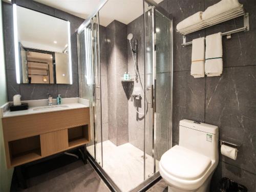 a bathroom with a shower and a toilet and a sink at City Comfort Inn Changsha Sifangping University of National Defense Science and Technology in Changsha