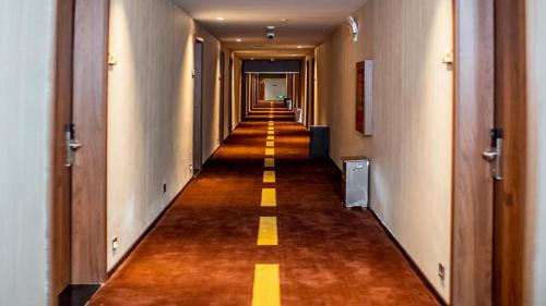 a hallway of a hotel with a long corridor at JTOUR Inn Wuhan Textile University in Liufangling