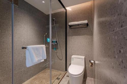 ein Badezimmer mit einem WC und einer Glasduschkabine in der Unterkunft City Comfort Inn Hotel Hefei Zhushi Beach Metro Station Railway Station in Qilitangzhen