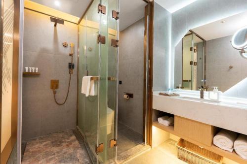 a bathroom with a shower and a sink at Borrman Hotel Wuhan Optics Valley Fozuling Gaoxin 4th Road in Liufangling