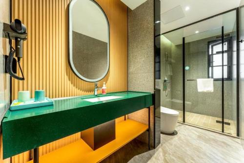 a bathroom with a sink and a mirror at City Comfort Inn Yichang Zhongnan Road Changjiang Plaza in Baiyang