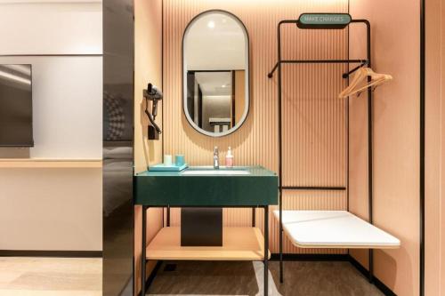 a bathroom with a green sink and a mirror at City Comfort Inn Yichang Zhongnan Road Changjiang Plaza in Baiyang