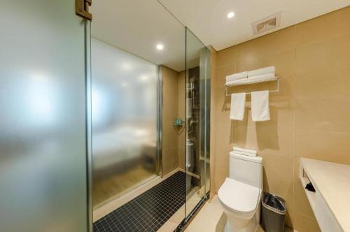 uma casa de banho com um WC e uma cabina de duche em vidro. em City Comfort Inn Beijing Capital Airport Shunyi Metro Station em Tahe