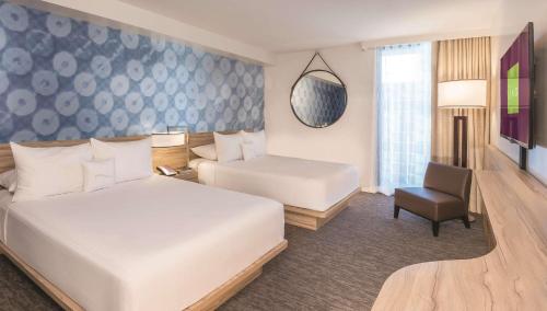 ein Hotelzimmer mit 2 Betten und einem Stuhl in der Unterkunft Coolest bar hoping Linq Casino Hotel Strip Las Vegas in Las Vegas